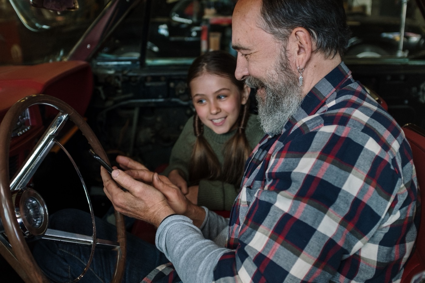 Padre e hija revisando un teléfono juntos