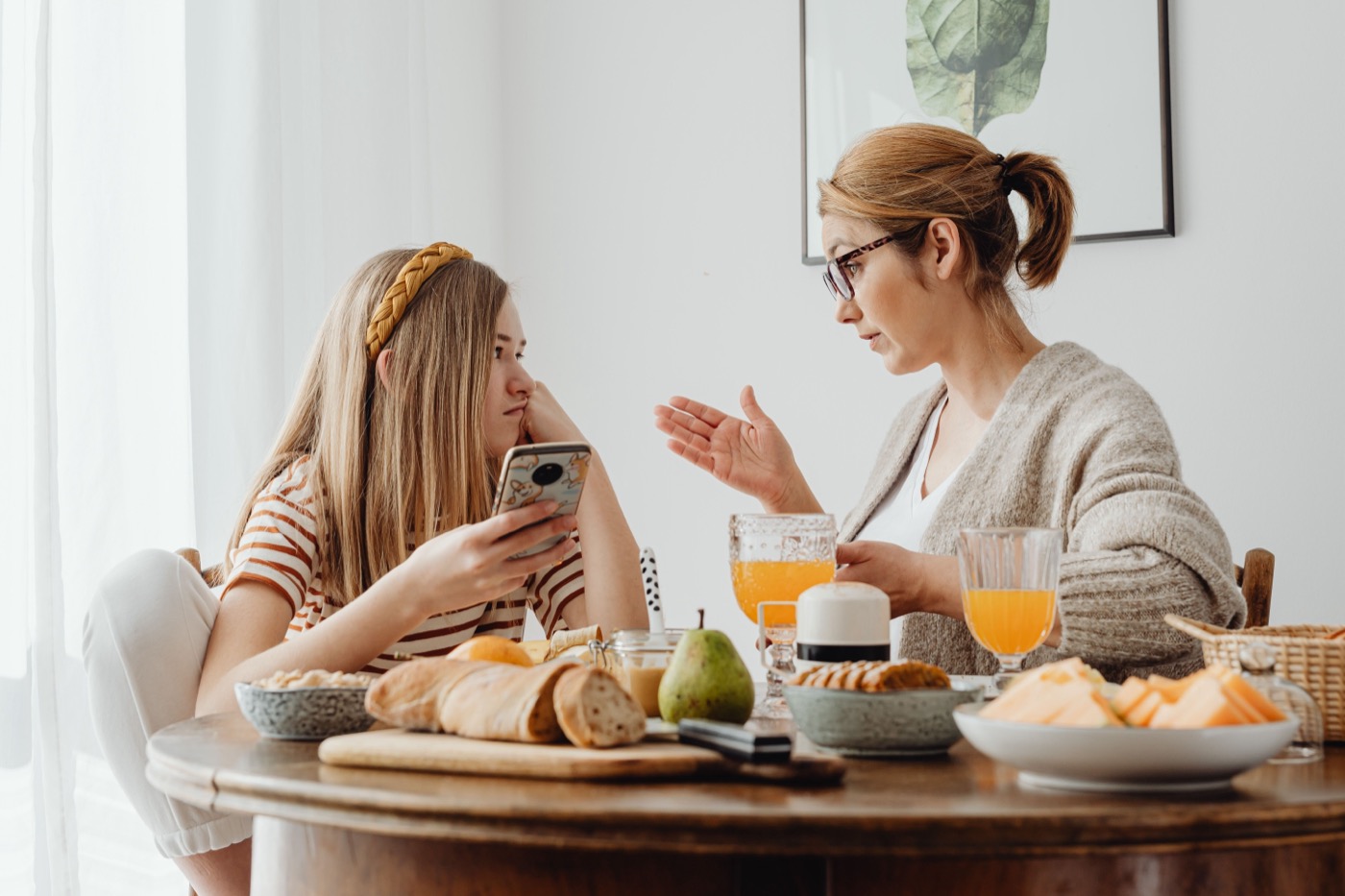 Madre conversando con su hija sobre el uso del teléfono