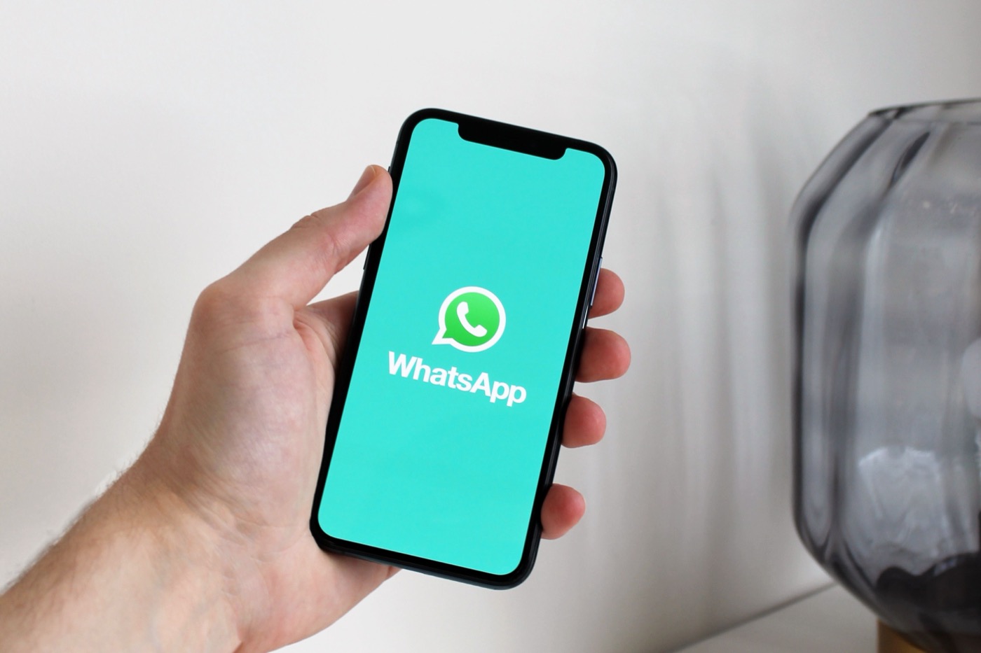 Mano sosteniendo un teléfono con WhatsApp abierto